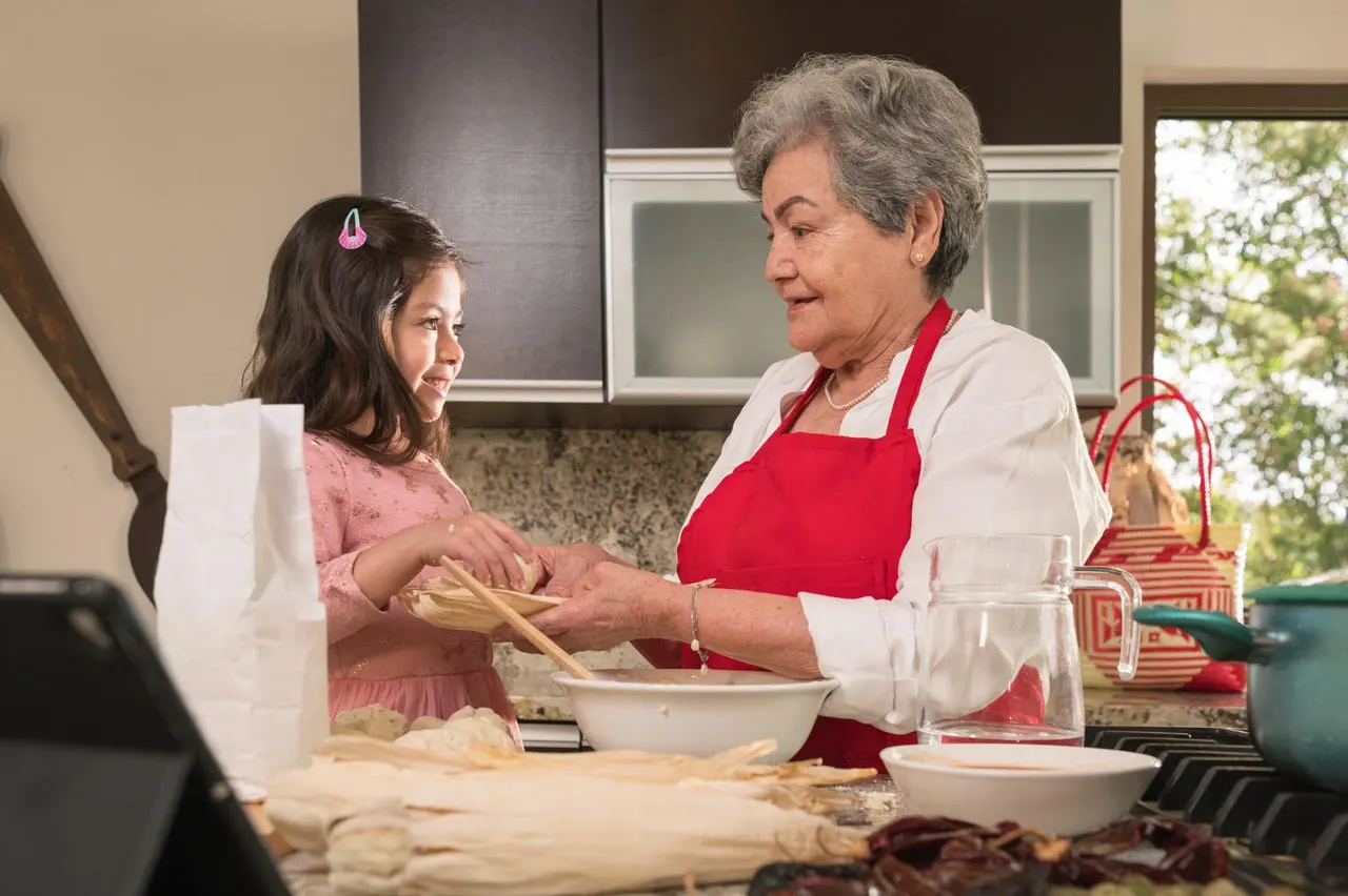 Elderly woman and a young girl cooking in the kitchen.